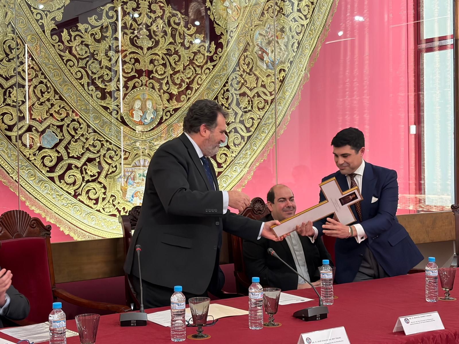 El hermano mayor de Los Estudiantes entrega una cruz muy especial al pregonero de la Semana Santa.