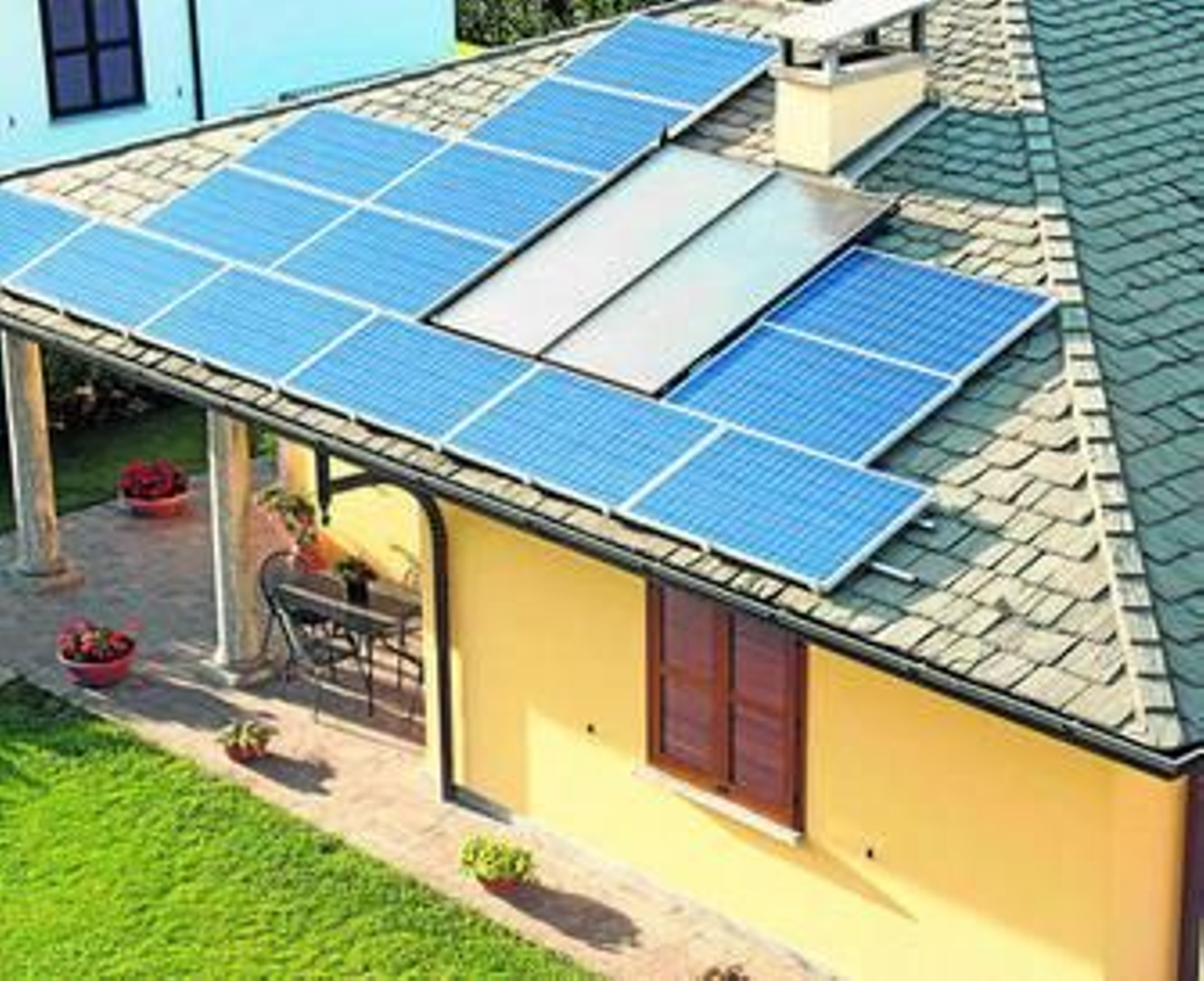 Una casa con varios paneles solares en el tejado. Una casa con varios paneles solares en el tejado.