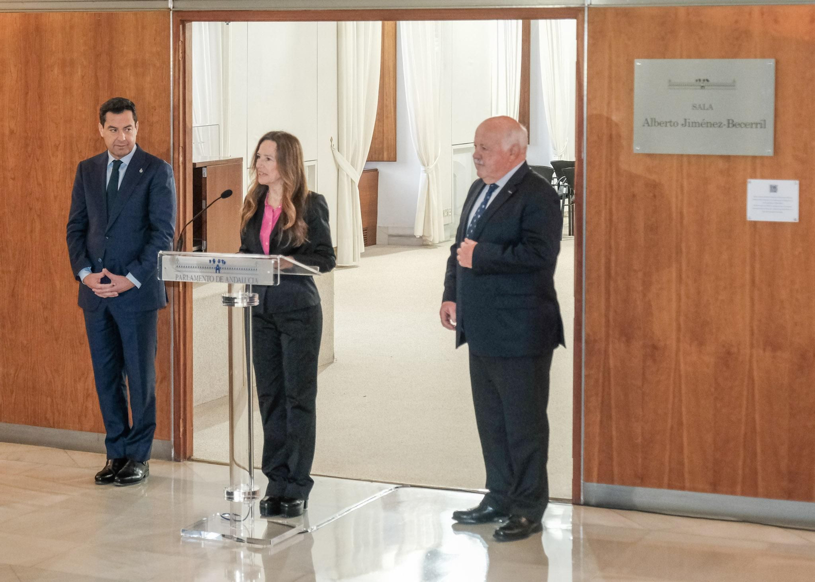 Teresa Jiménez Becerril junto al presidente del Parlamento, Jesús Aguirre y el de la Junta, Juanma Moreno, en la inauguración de la sala que lleva el nombre de su hermano asesinado por ETA.