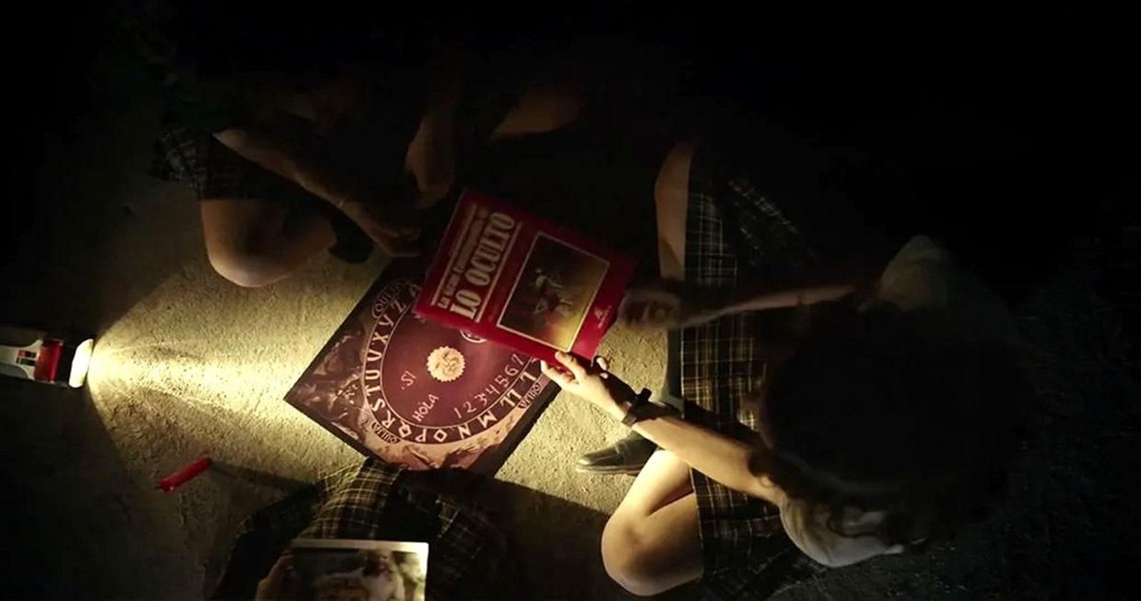varias personas realizan una ouija.
