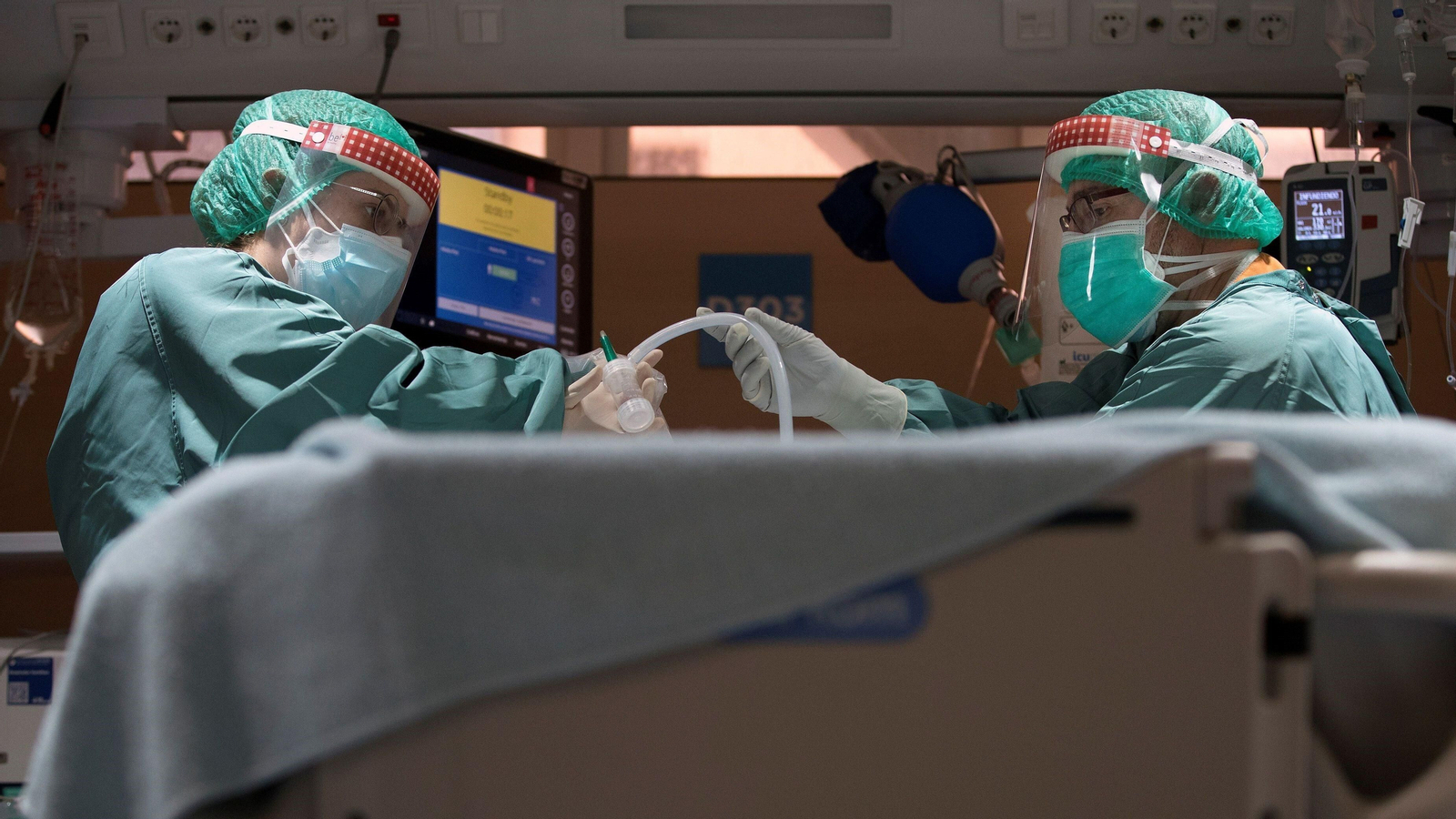 Dos profesionales sanitarios asisten a un paciente covid en una UCI. Dos profesionales sanitarios asisten a un paciente covid en una UCI.