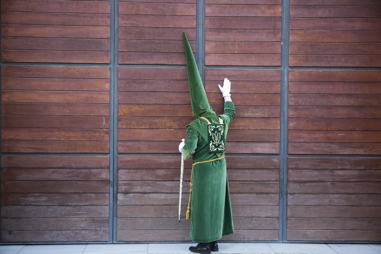 Un nazareno de Estudiantes, ante las puertas de su casa hermandad.