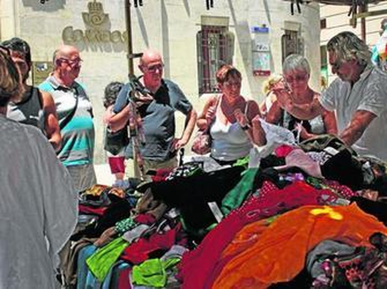 Un grupo de turistas se paran frente a un puesto situado en el exterior del Mercado Central.