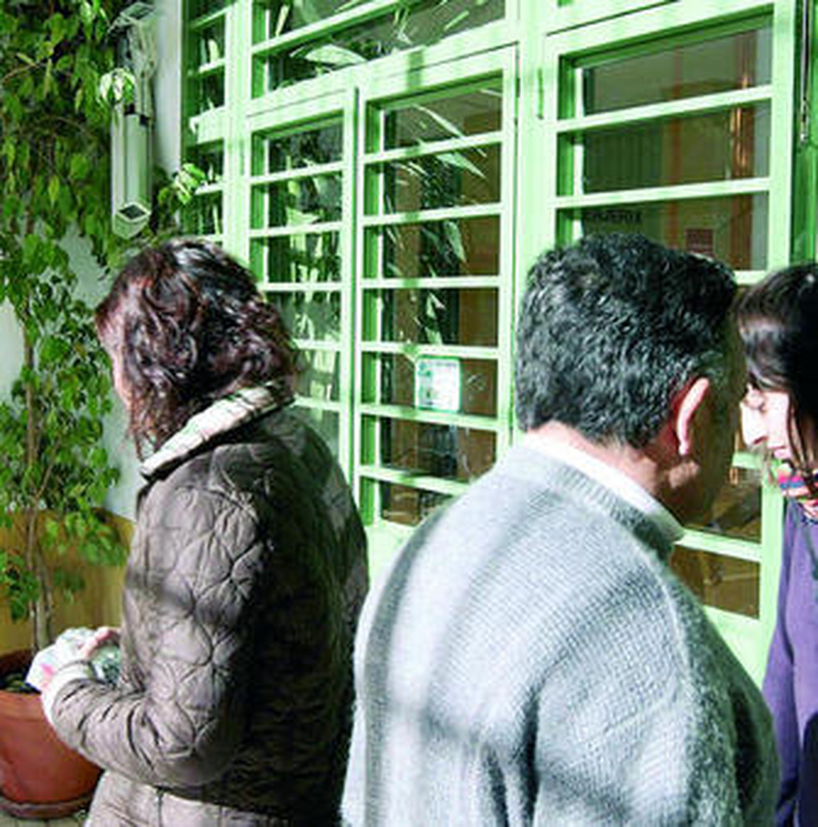 Varias personas, en la puerta del centro.