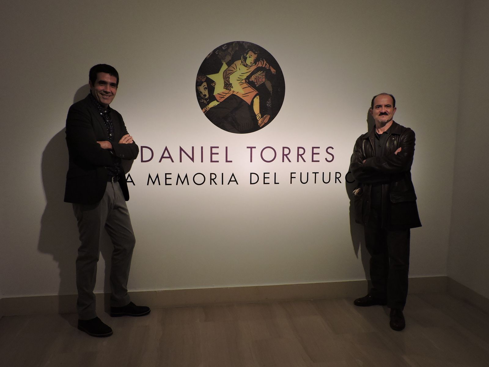 Daniel Torres y Abel Ippólito, autor y comisario, en la Casa de la Provincia, ante el cartel anunciador de la exposición.