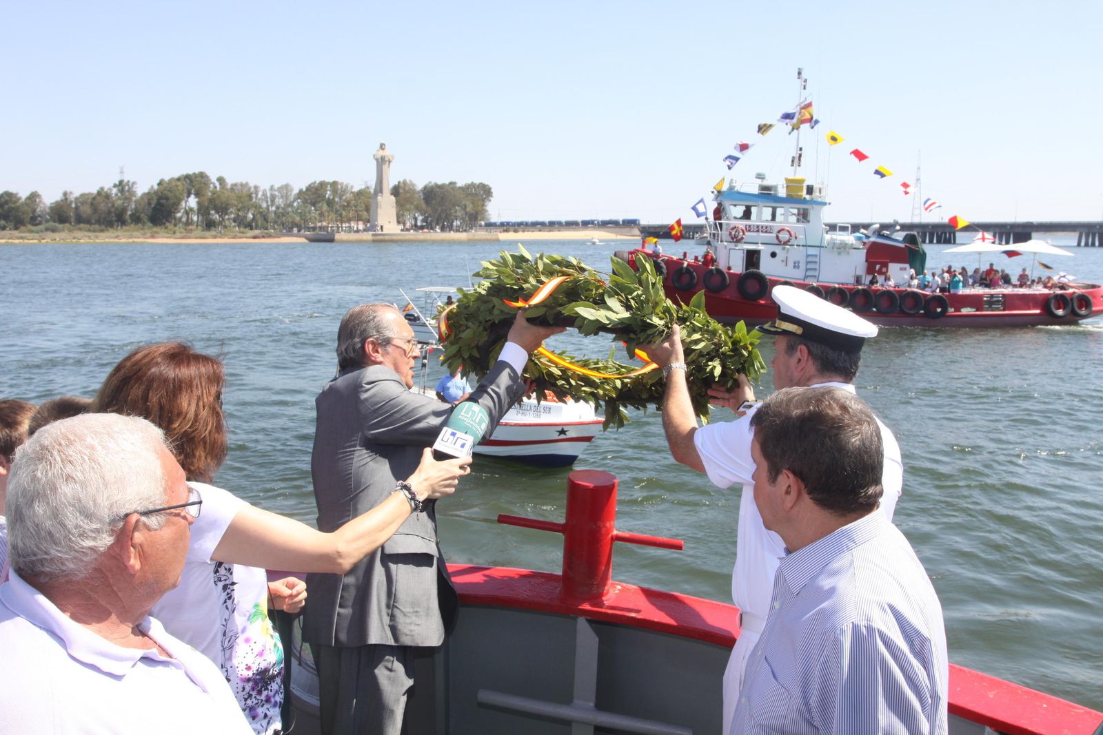 Ofrenda floral en memoria de los fallecidos en el mar durante la procesión de la Virgen del Carmen por la ría de Huelva.