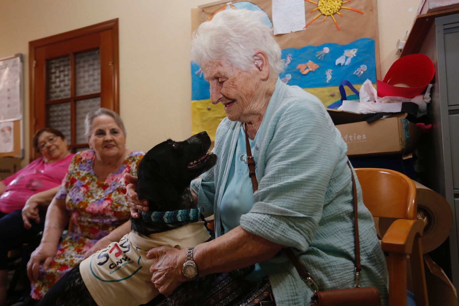 Una de las residentes abraza a un perro de la protectora.