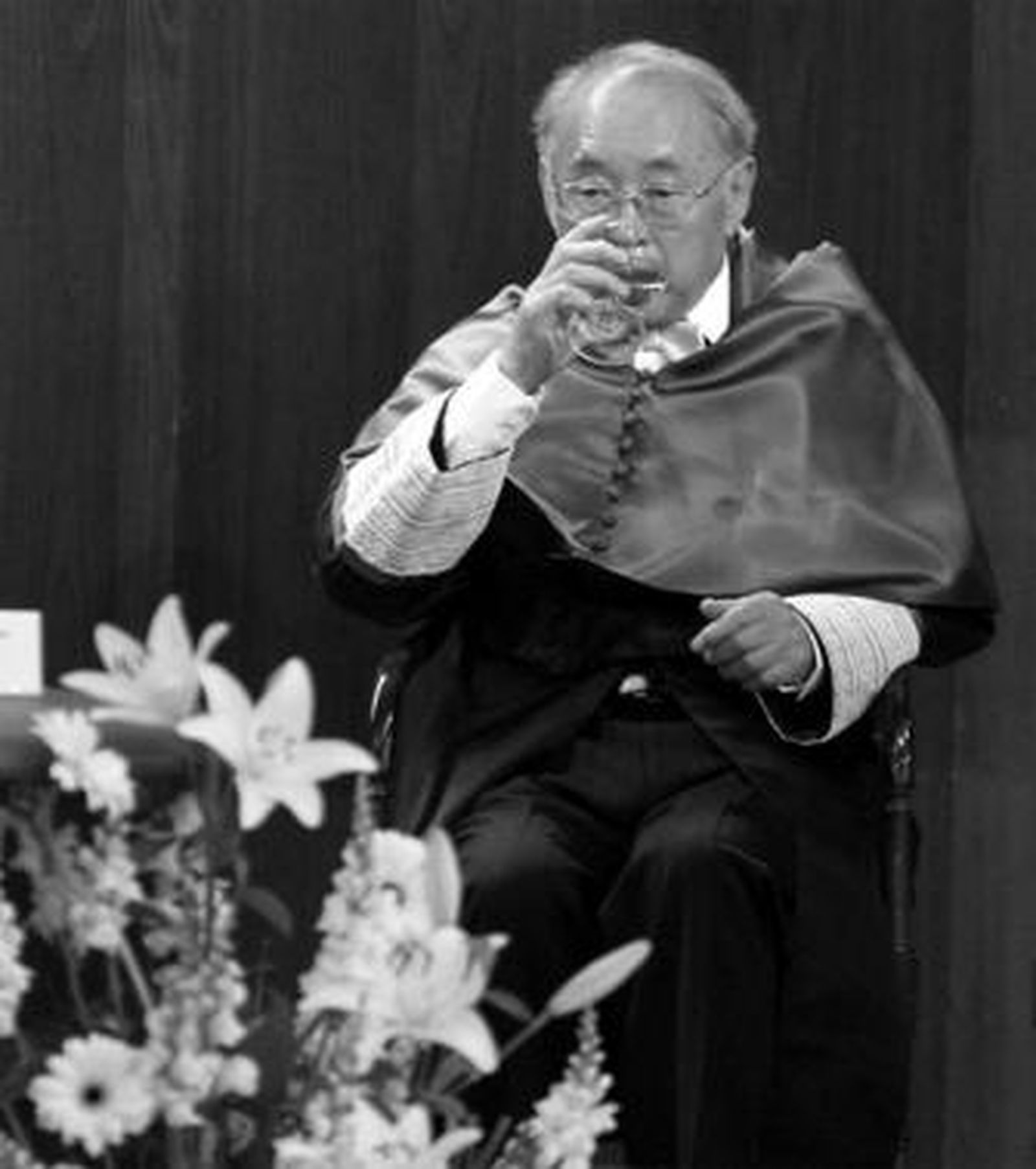 El científico de origen japonés Takashi Asano bebe agua justo antes de recibir el birrete de la UCA.