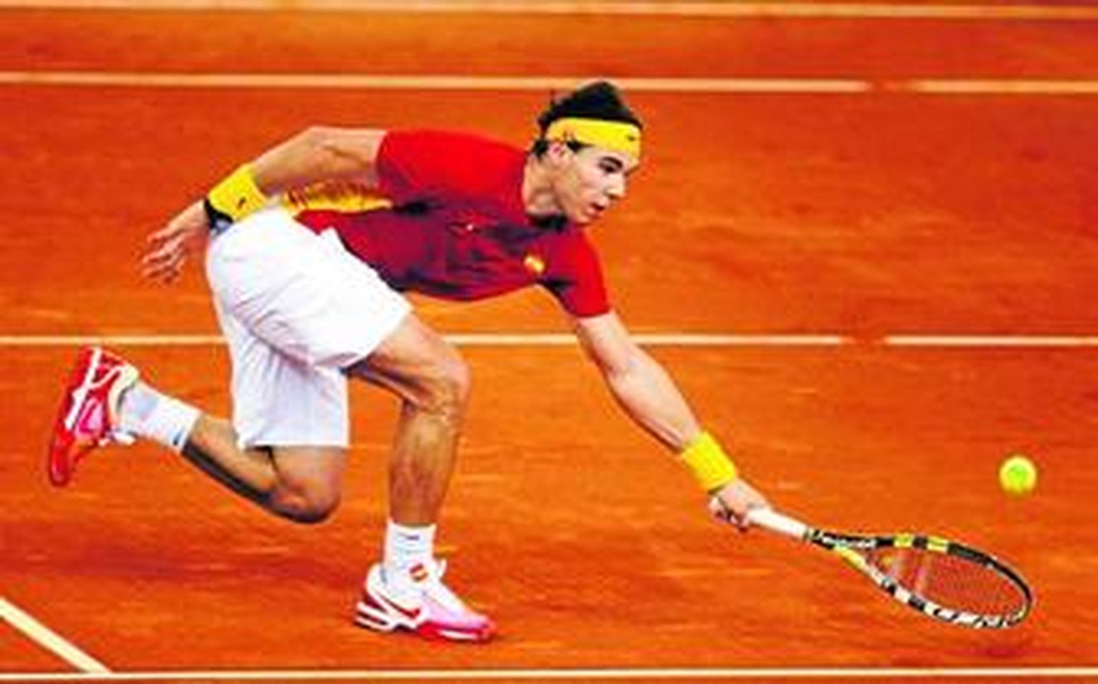 Rafa Nadal se vale de sus potentísimas piernas para intentar devolver una bola baja que le envió Juan Martín del Potro.