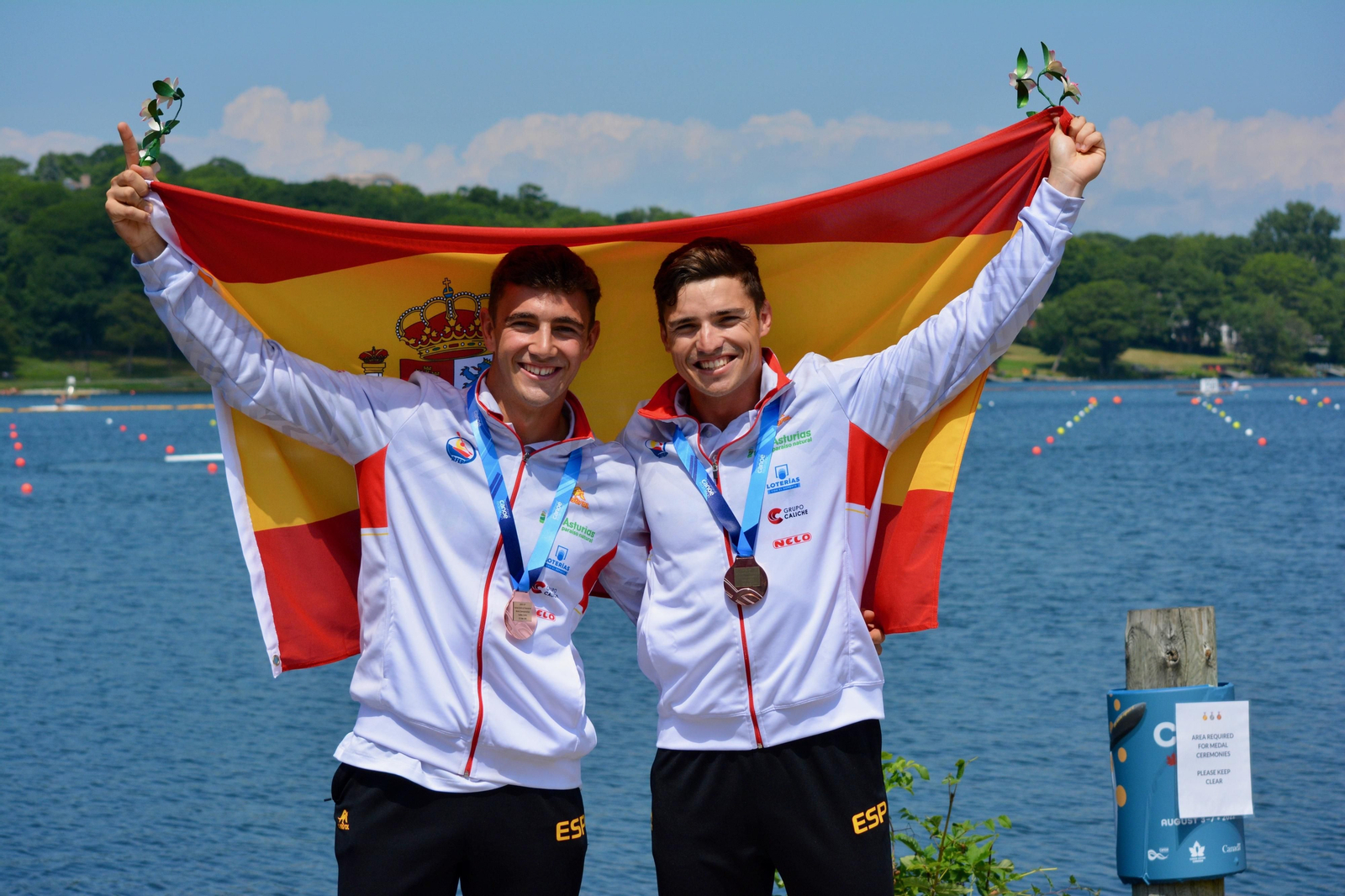 Tano García de la Borbolla y Pablo Martínez, con la medalla de oro tras el C-2 500 y la bandera de España.