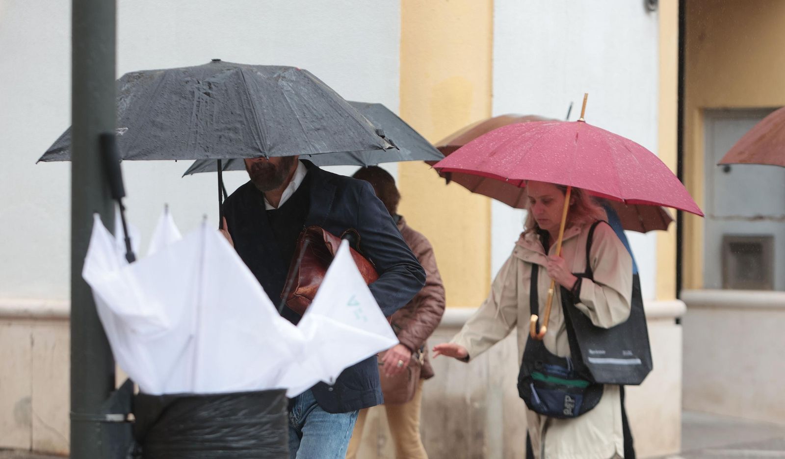 Varias personas con paraguas caminando bajo la lluvia en una calle del centro de Jerez