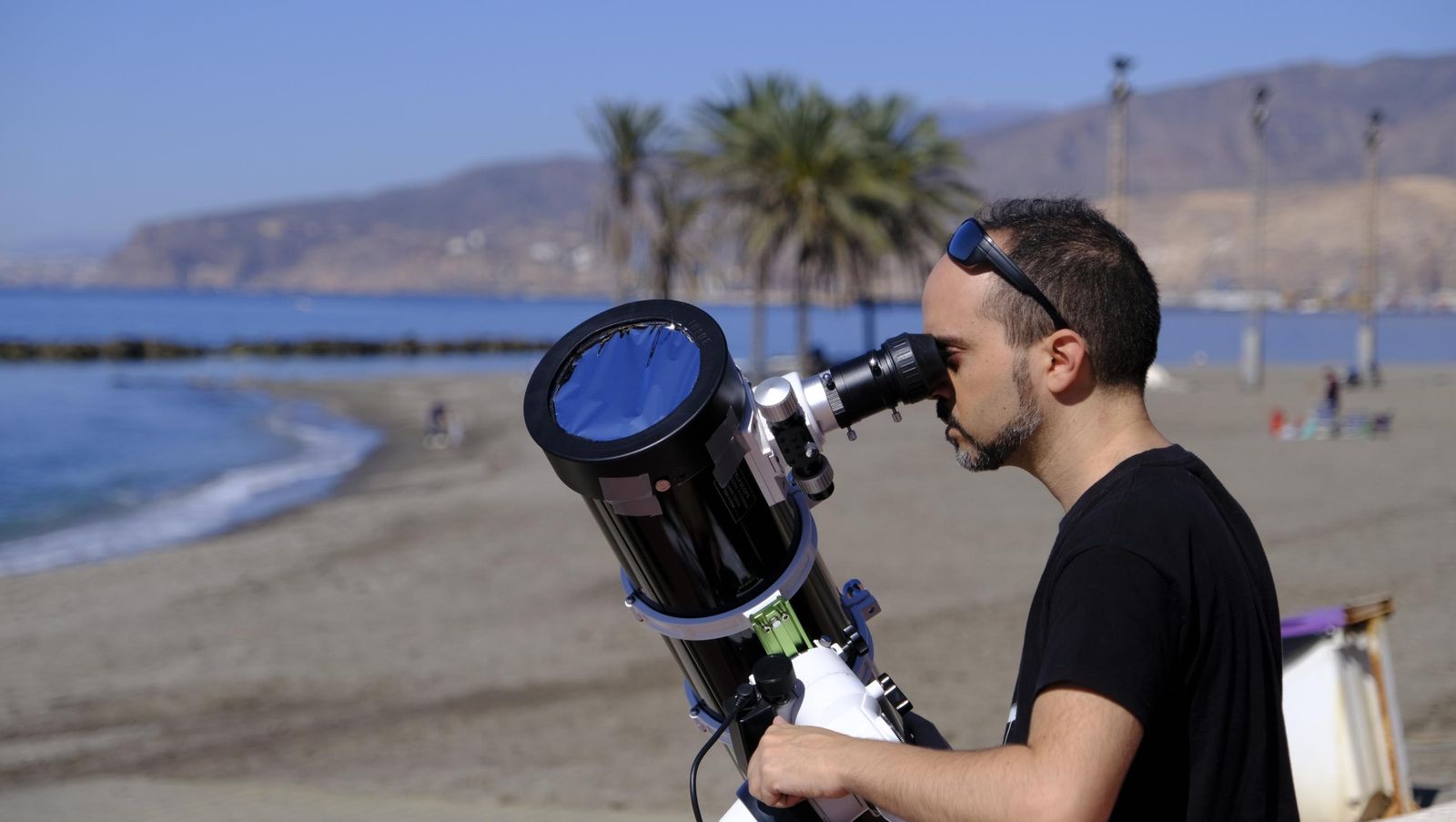 Almería observa el eclipse solar desde el Paseo Marítimo, en imágenes