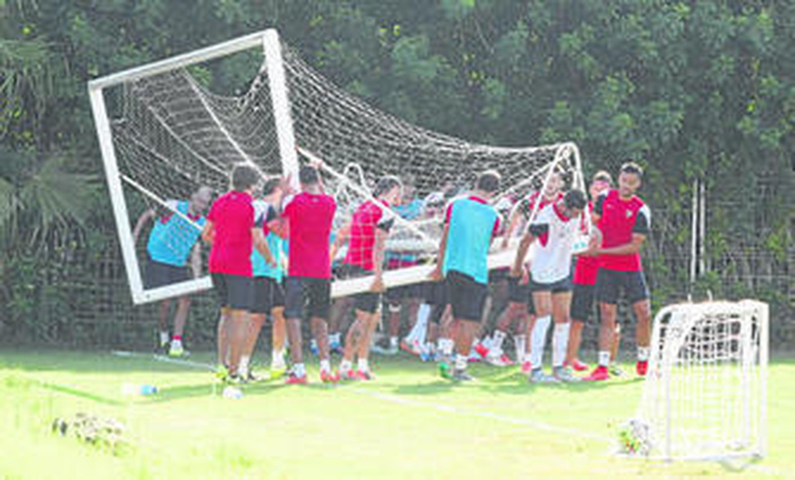 Los jugadores rojiblancos cargan una de las porterías en un entrenamiento.