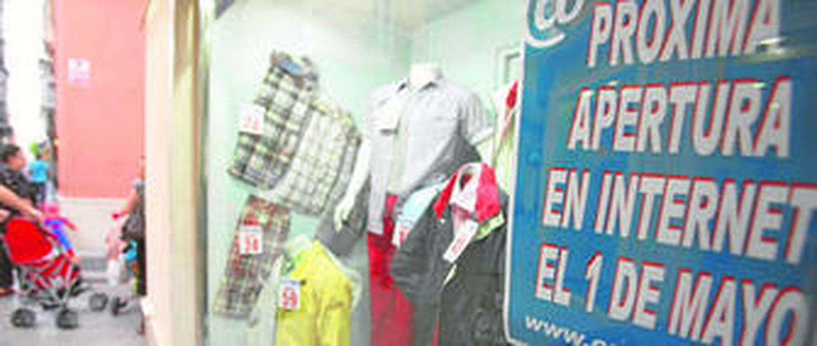 Un comercio anuncia la apertura de su página web en el escaparate.