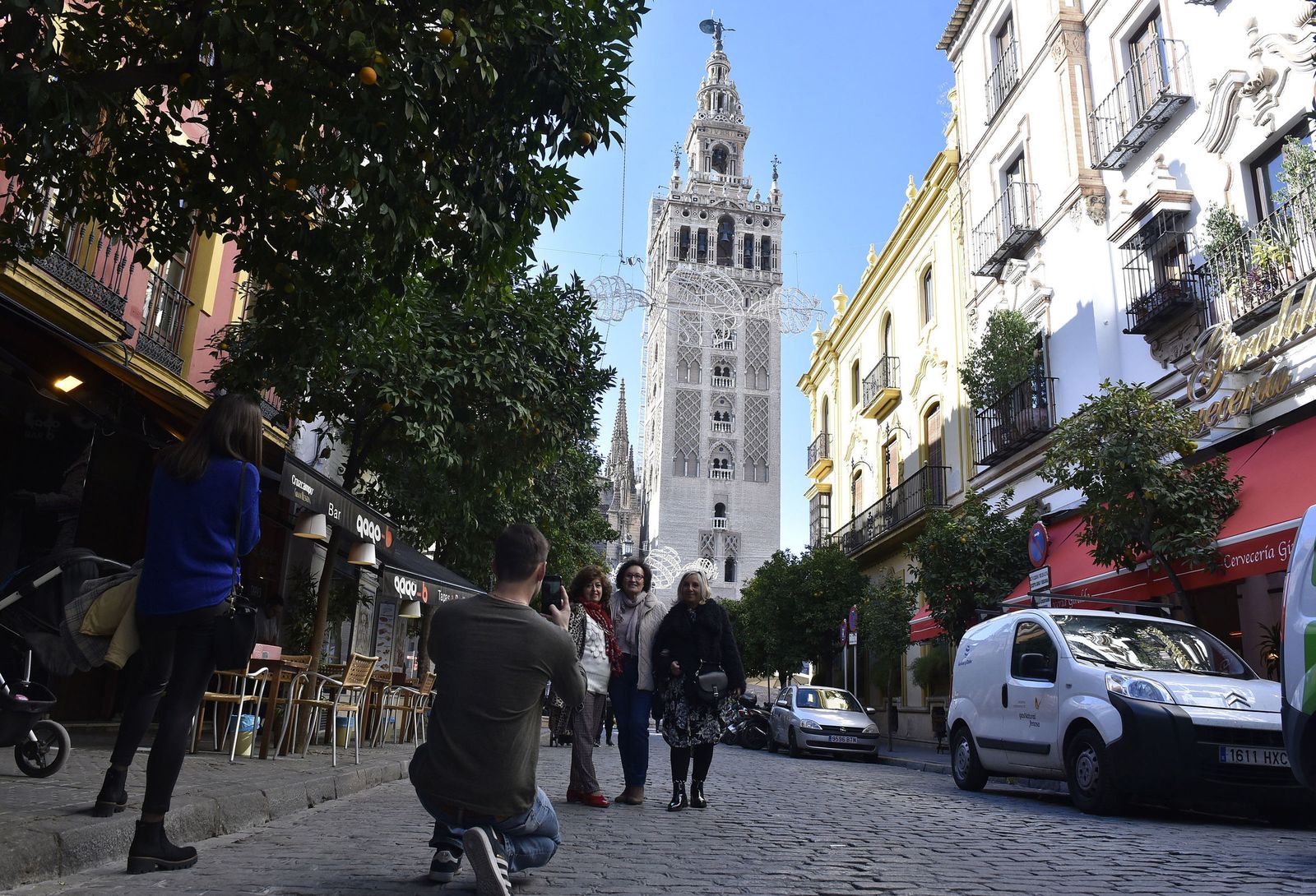 Un grupo de personas se fotografía ante la Giralda en la calle Mateso Gago