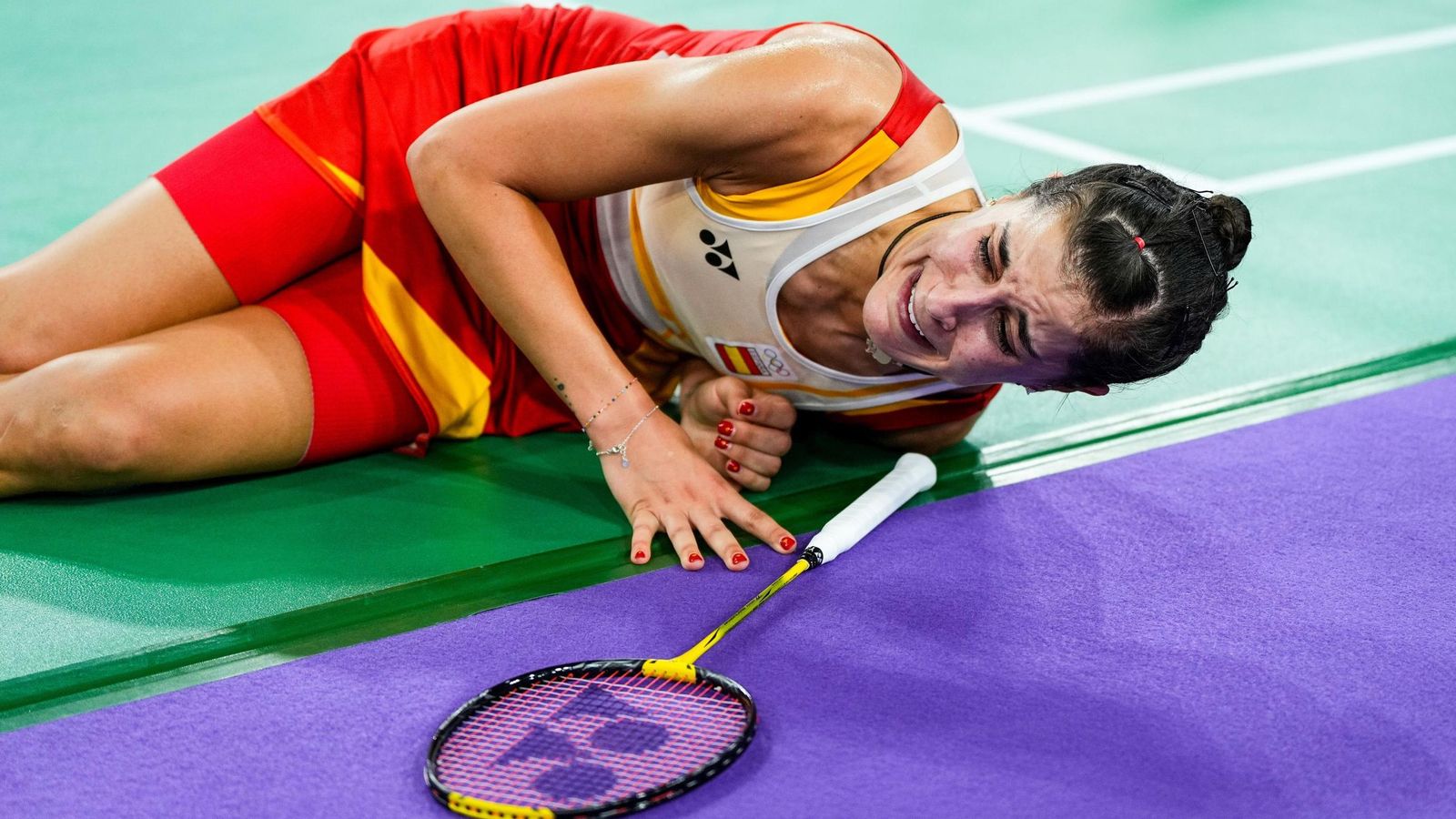 Carolina Marín se duele en la pista tras su lesión.