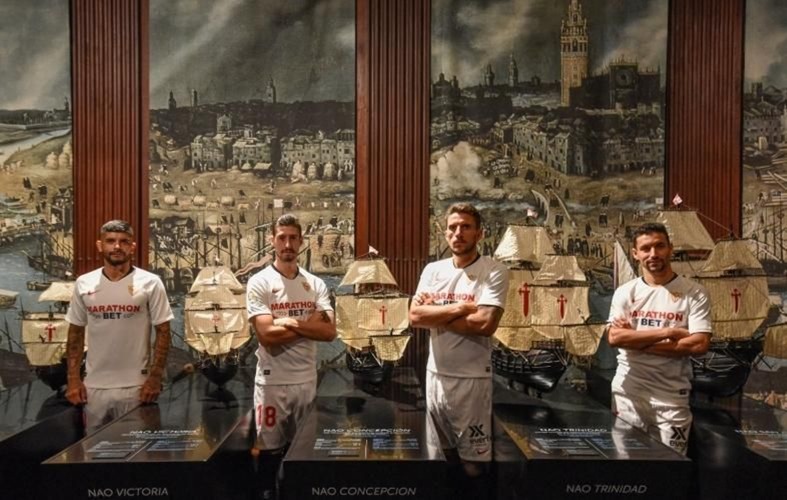 Los capitanes del Sevilla, antes las maquetas de las naos, en la exposición 'El viaje más largo'.