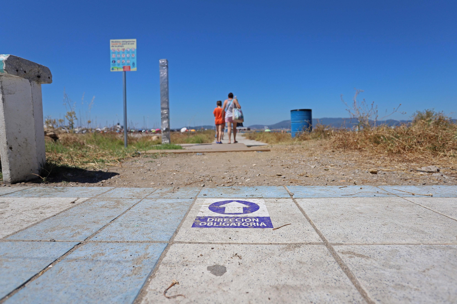 Dos personas acceden a una playa de la comarca.