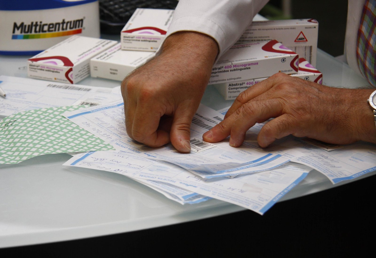 Un farmacéutico pone el sello a varias recetas médicas.