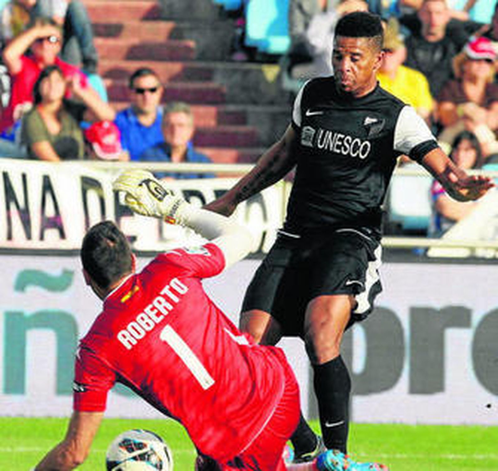 Eliseu no logra alcanzar el balón frente a Roberto.