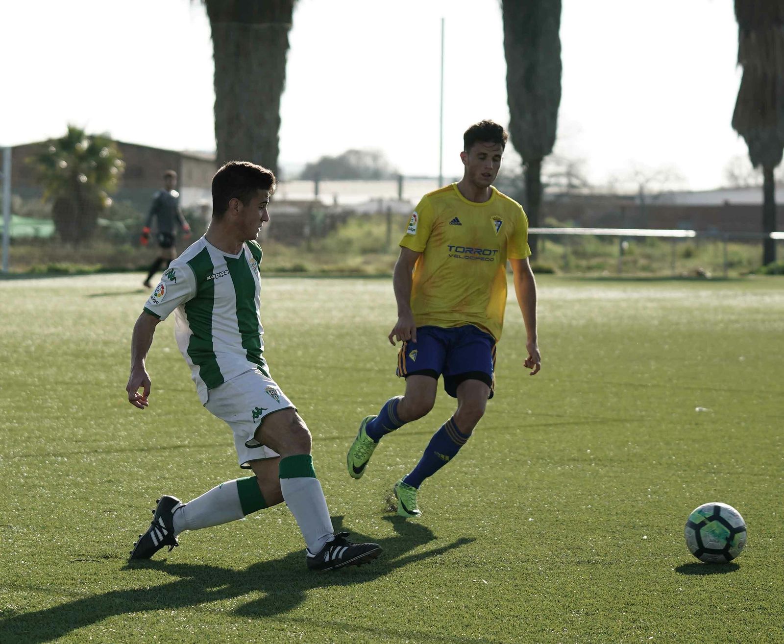 Un jugador del Córdoba pasa el balón en presencia de un rival del Balón de Cádiz.