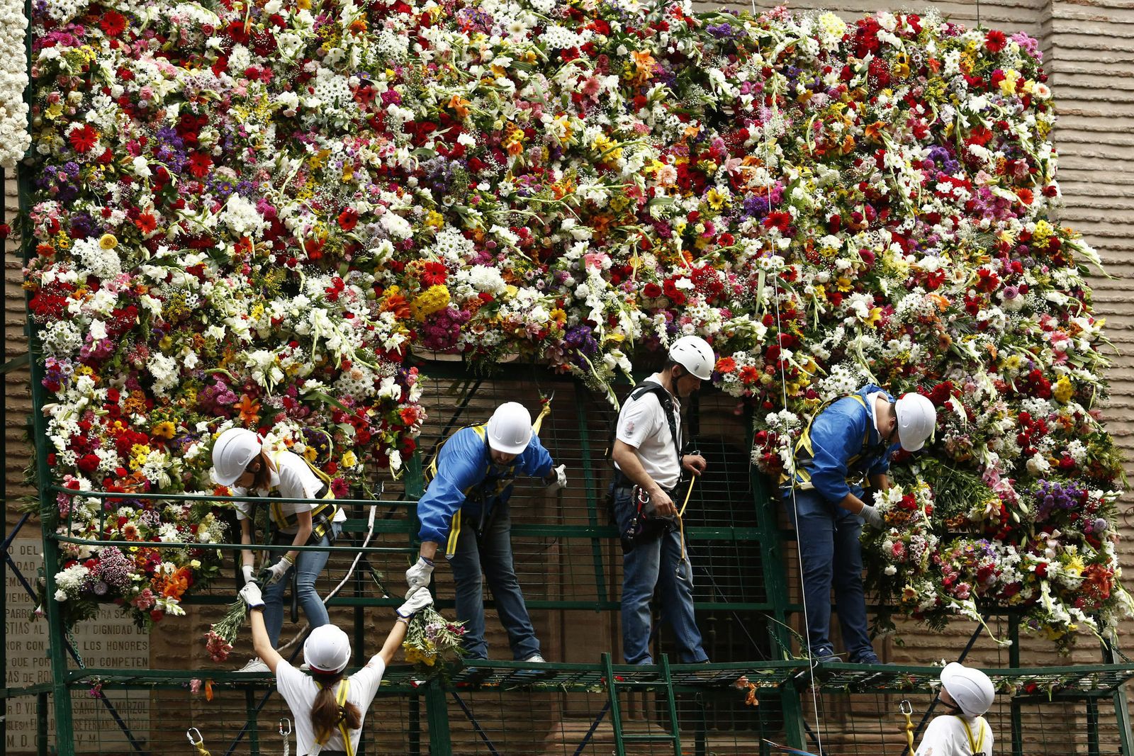 Imagen de los operarios colocando las flores en la basílica de la Virgen de las Angustias