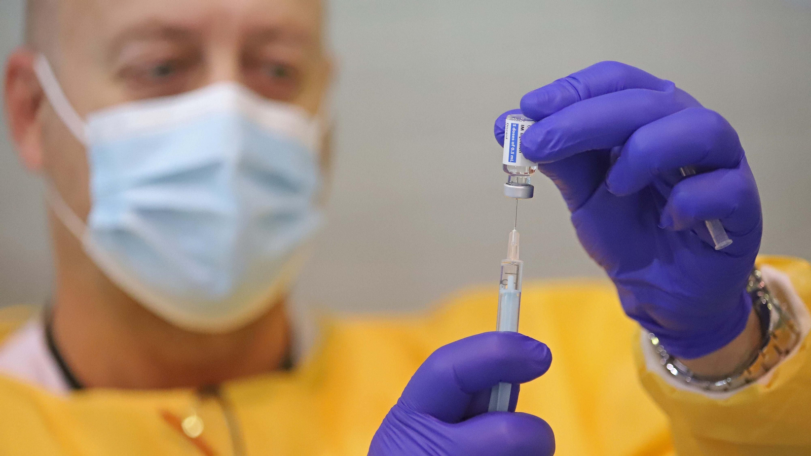 Un sanitario prepara una vacuna.