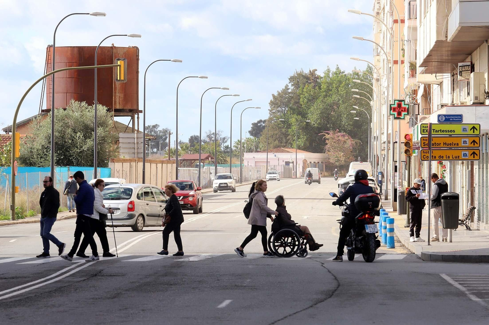 Varias personas cruzan un paso de peatones de la capital onubense.