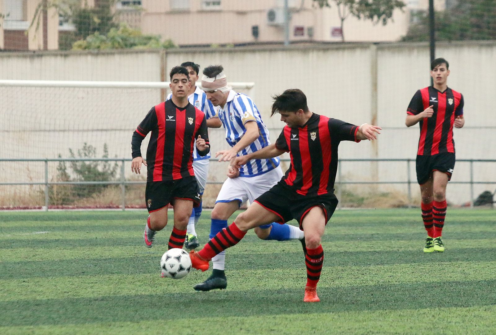 Un jugador del Séneca controla el balón ante la presión de un jugador recreativista.