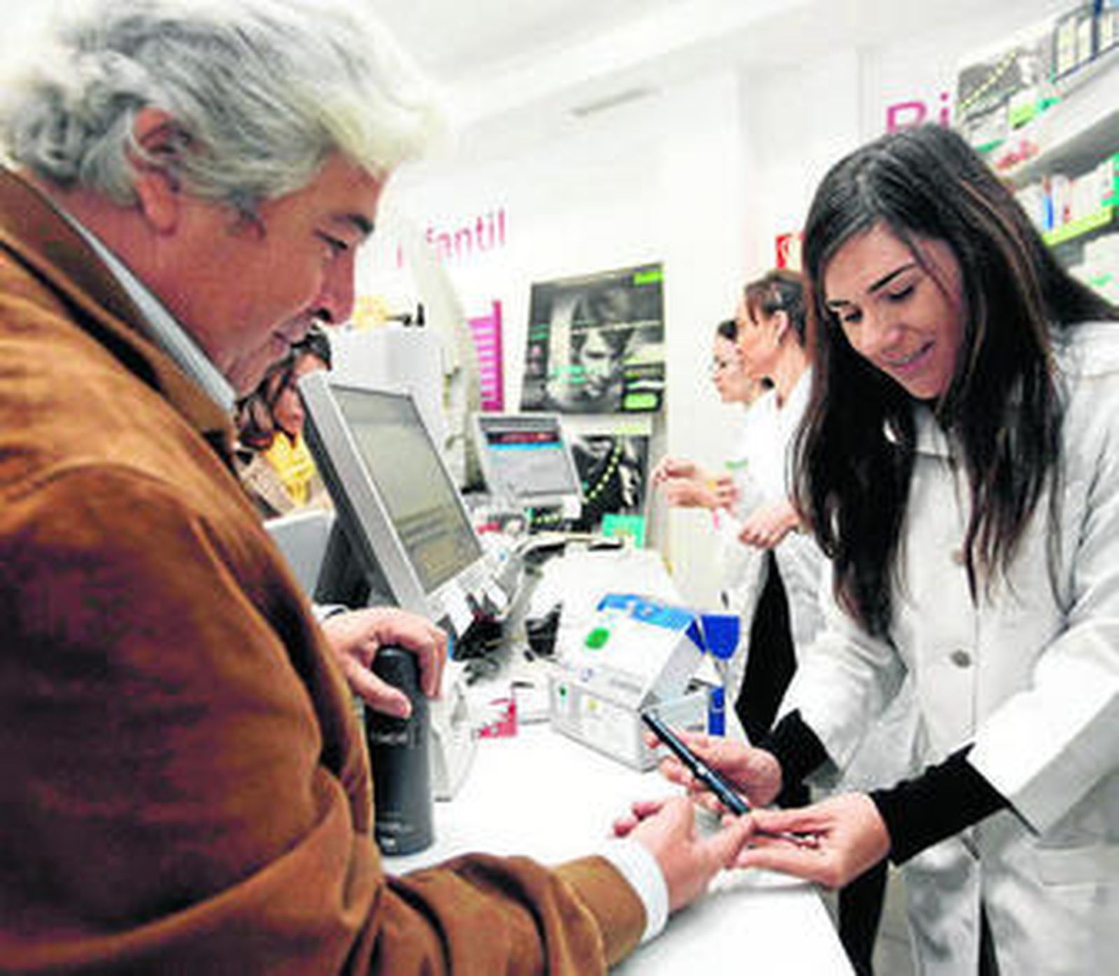 Un hombre se somete a una prueba de glucemia realizada en una farmacia.