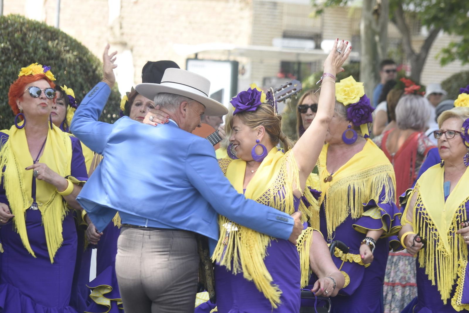 Dos componentes de un coro bailan unas sevillanas antes de entrar en el puente de El Arenal.