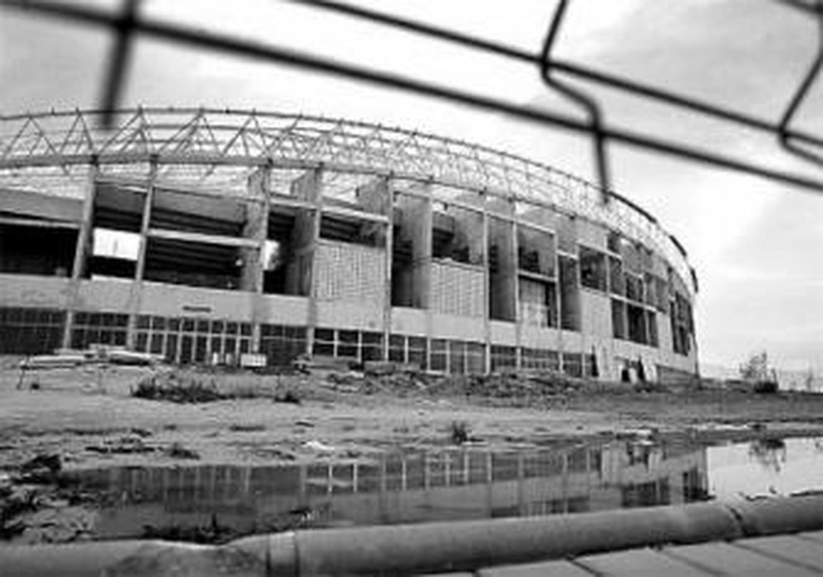 1. Vista exterior tomada ayer por la tarde del estadio de atletismo Ciudad de Málaga. 2. La pared de uno de los muros que bordea el estadio, con una grieta que demuestra el mal estado en el que la instalación y sus alrededores se han mantenido.  3. Las pistas, que no presentan el mejor aspecto posible, y el césped, descuidado y quemado por la falta de cuidado, son otras de las zonas afectadas por el retraso de la obra en el estadio de atletismo Ciudad de Málaga. Reportaje gráfico: Victoriano Moreno.