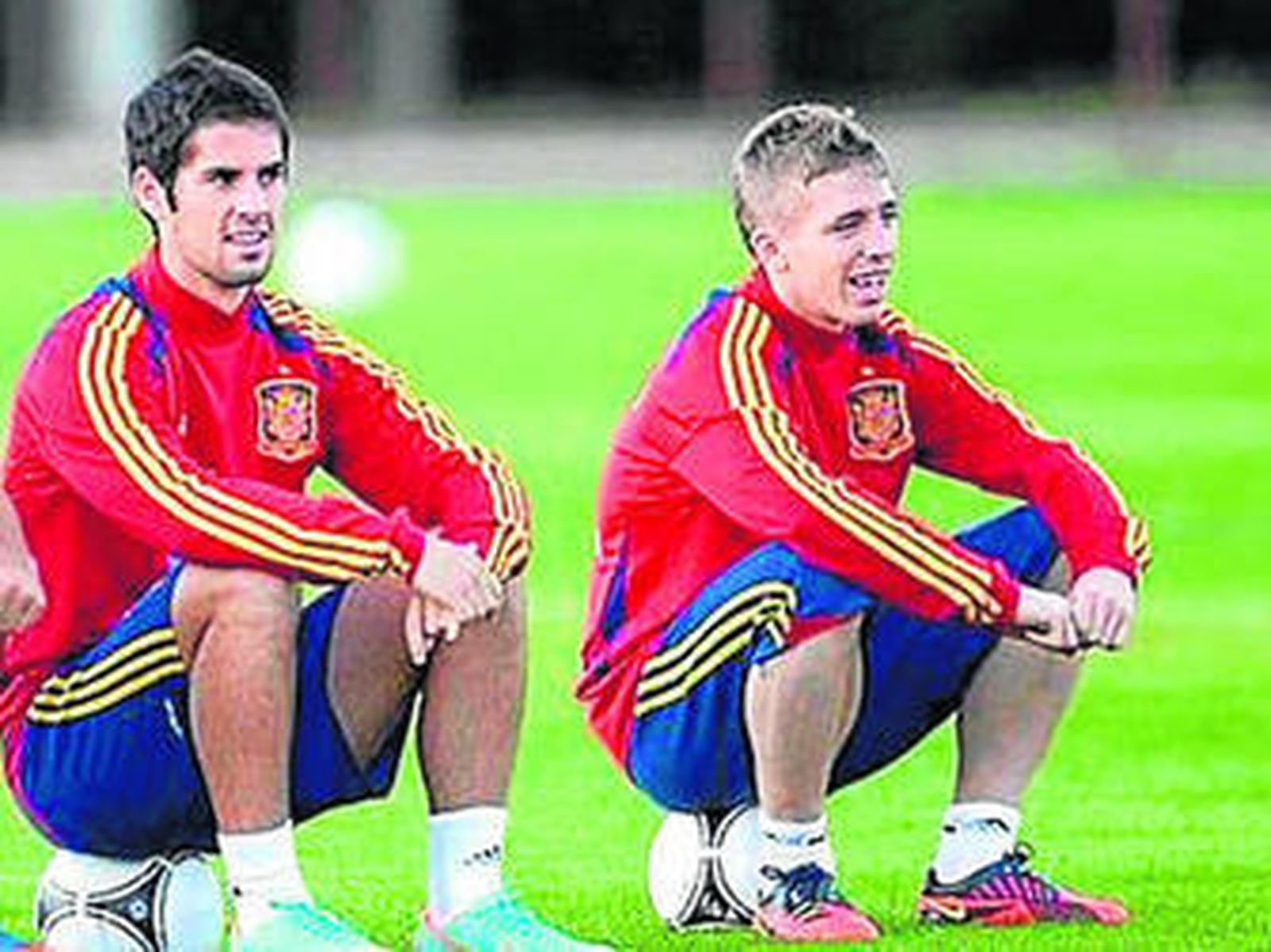 Isco (i) y Muniain observan sentados el trabajo de sus compañeros.