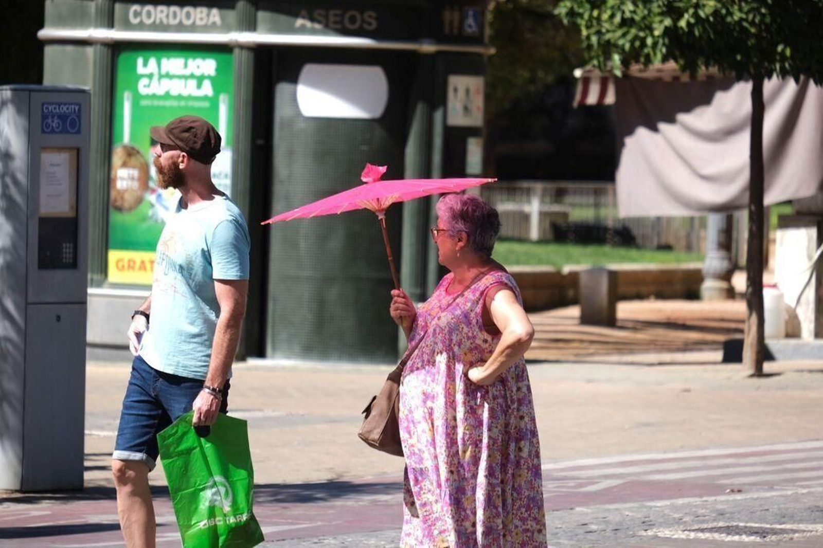 Una mujer se refugia del sol bajo una sombrilla en Córdoba.