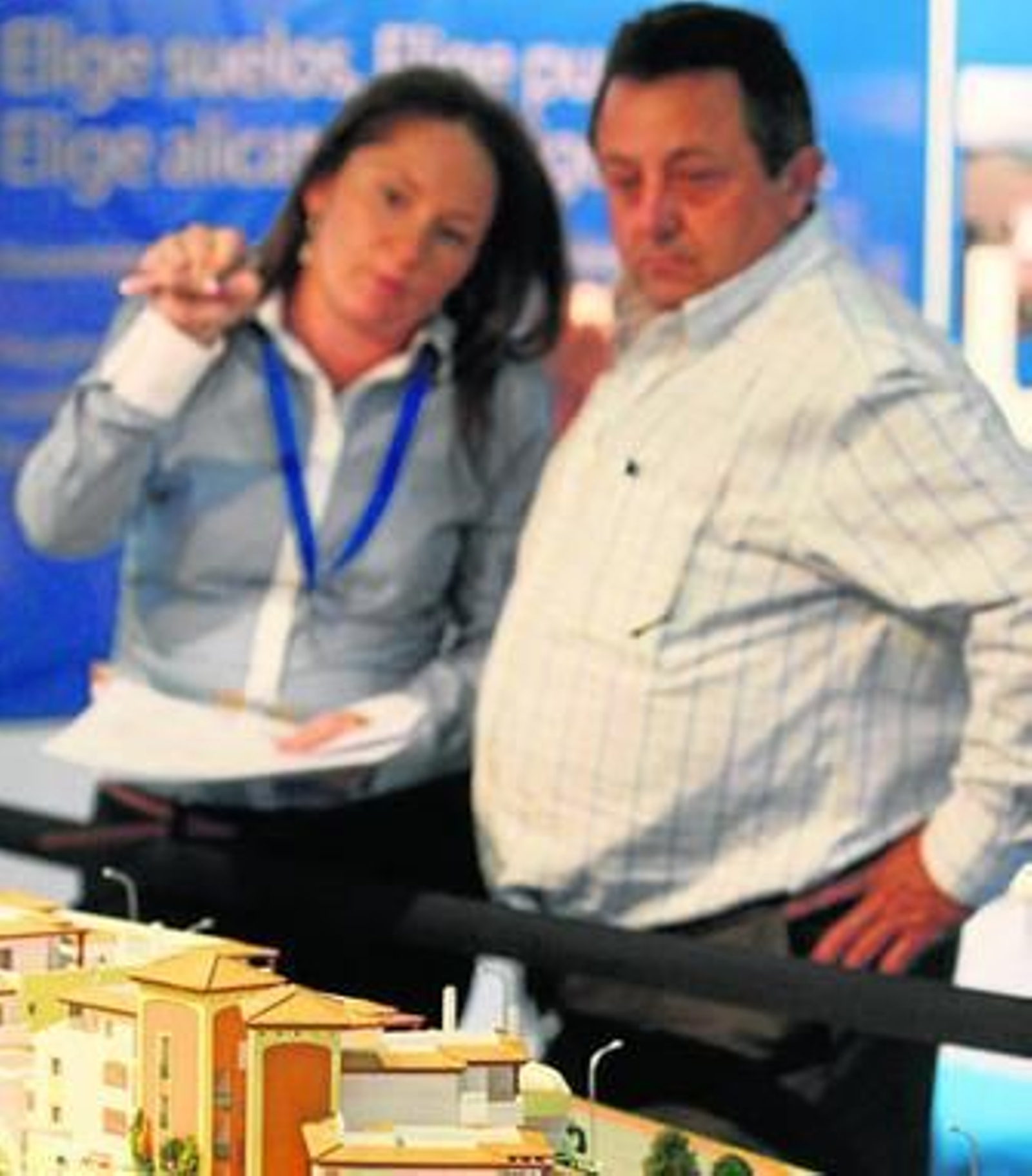 Dos personas observan la maqueta de una promoción inmobiliaria en Málaga.