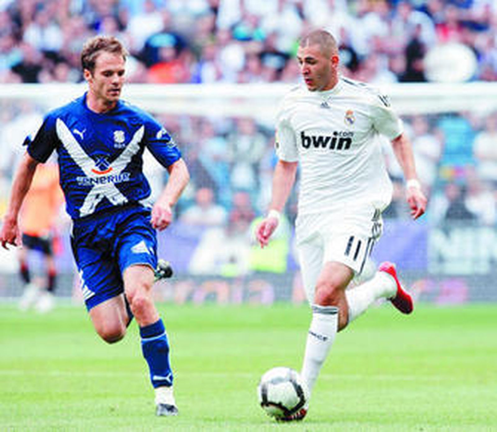Benzema conduce el balón presionado por el tinerfeño Mikel Alonso.