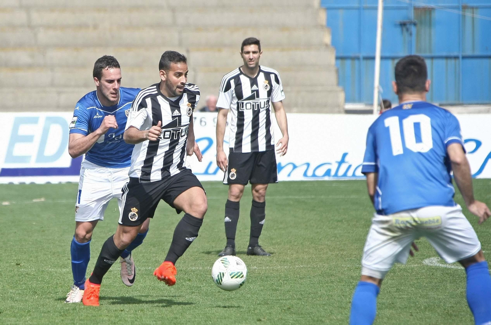 Canario conduce el balón, perseguido por Casi, del Linares.