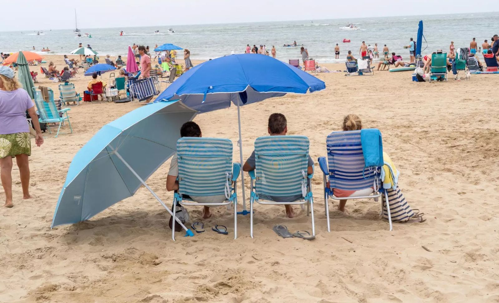 Varias personas disfrutan de una mañana nubosa en la playa de El Portil.