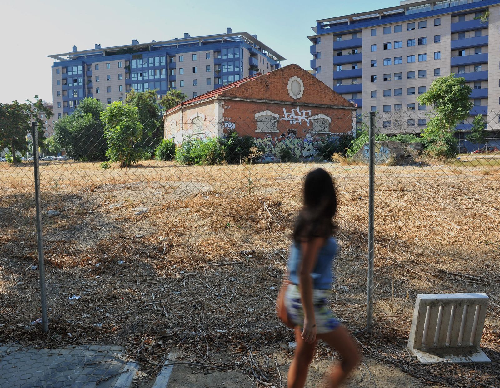 Una mujer pasa junto al solar de la calle Campamento que será un aparcamiento.