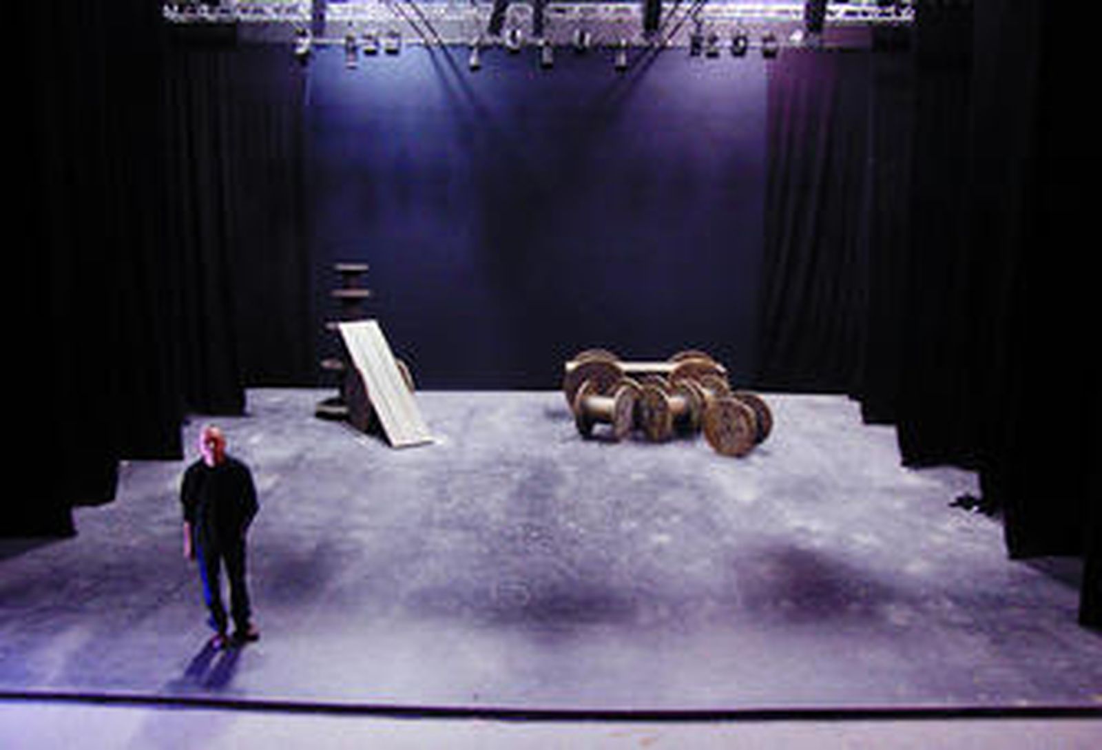 Ricardo Iniesta posa en el escenario del Centro TNT, al fondo las bobinas de madera que forman parte del decorado de 'Divinas palabras'.