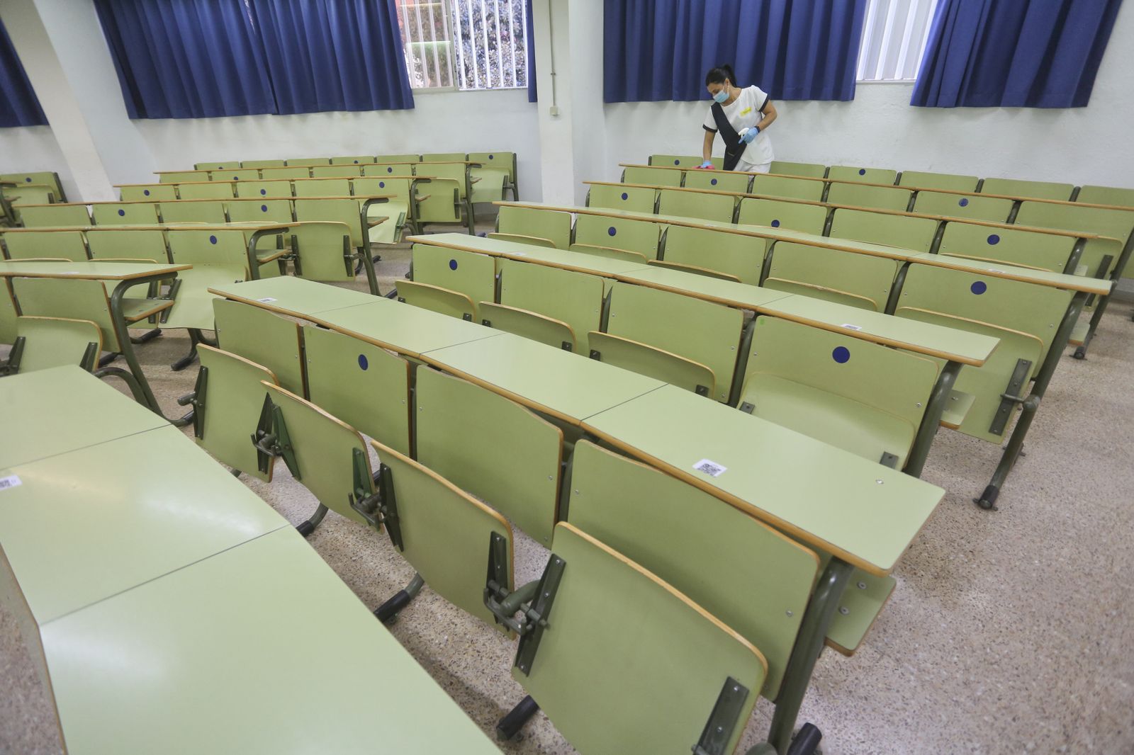 Una limpiadora desinfecta las mesas de un aula de la Facultad de Ciencias de la UMA.