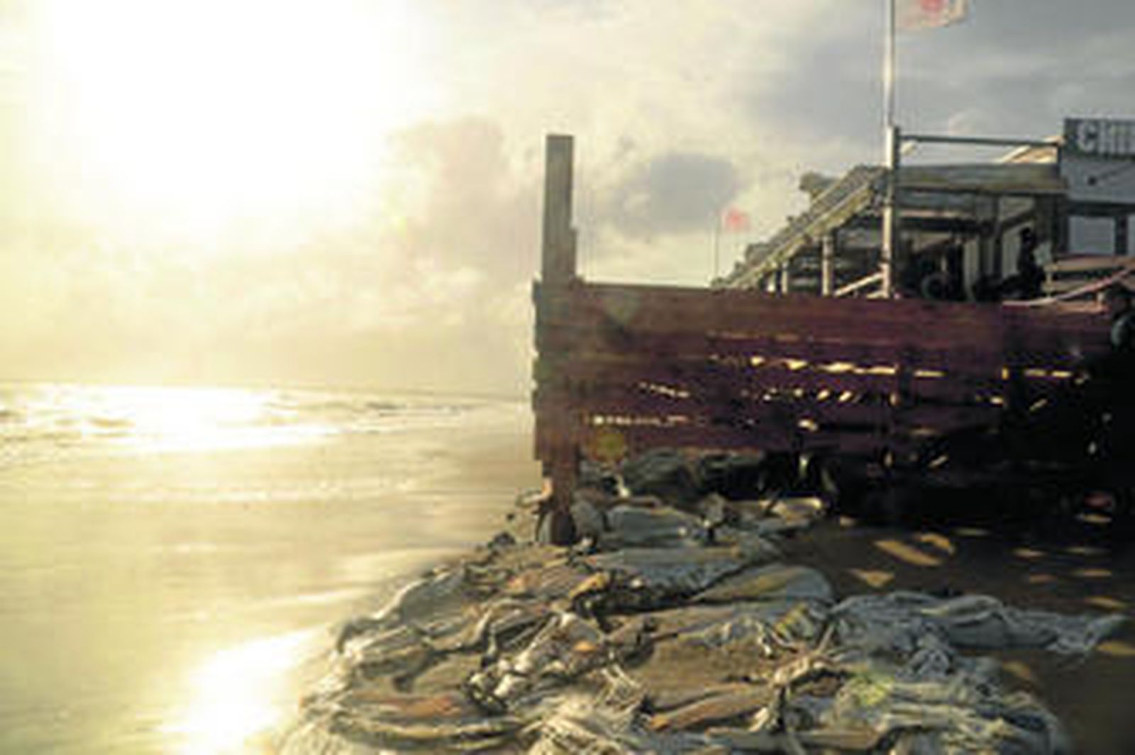 A merced del oleaje, el chiringuito El Paradise Beach, en Isla Canela, uno de los establecimientos más afectados por el temporal en la provincia onubense, en la tarde del lunes.