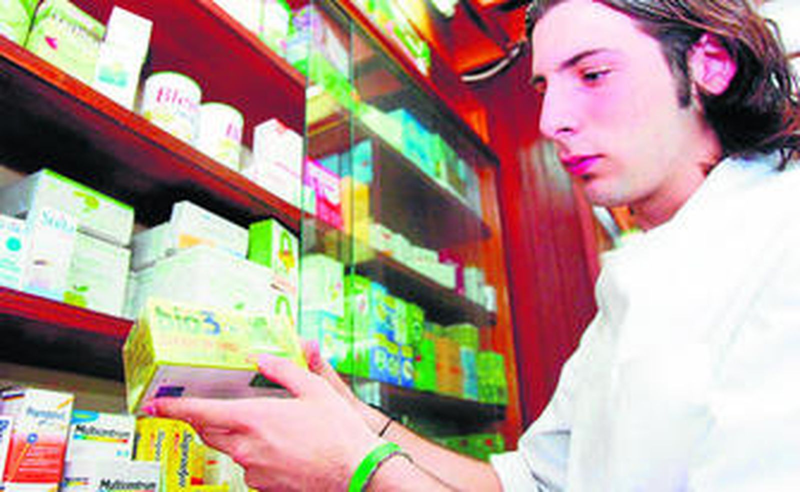 Un farmacéutico sostiene un producto dietético basado en plantas medicinales.