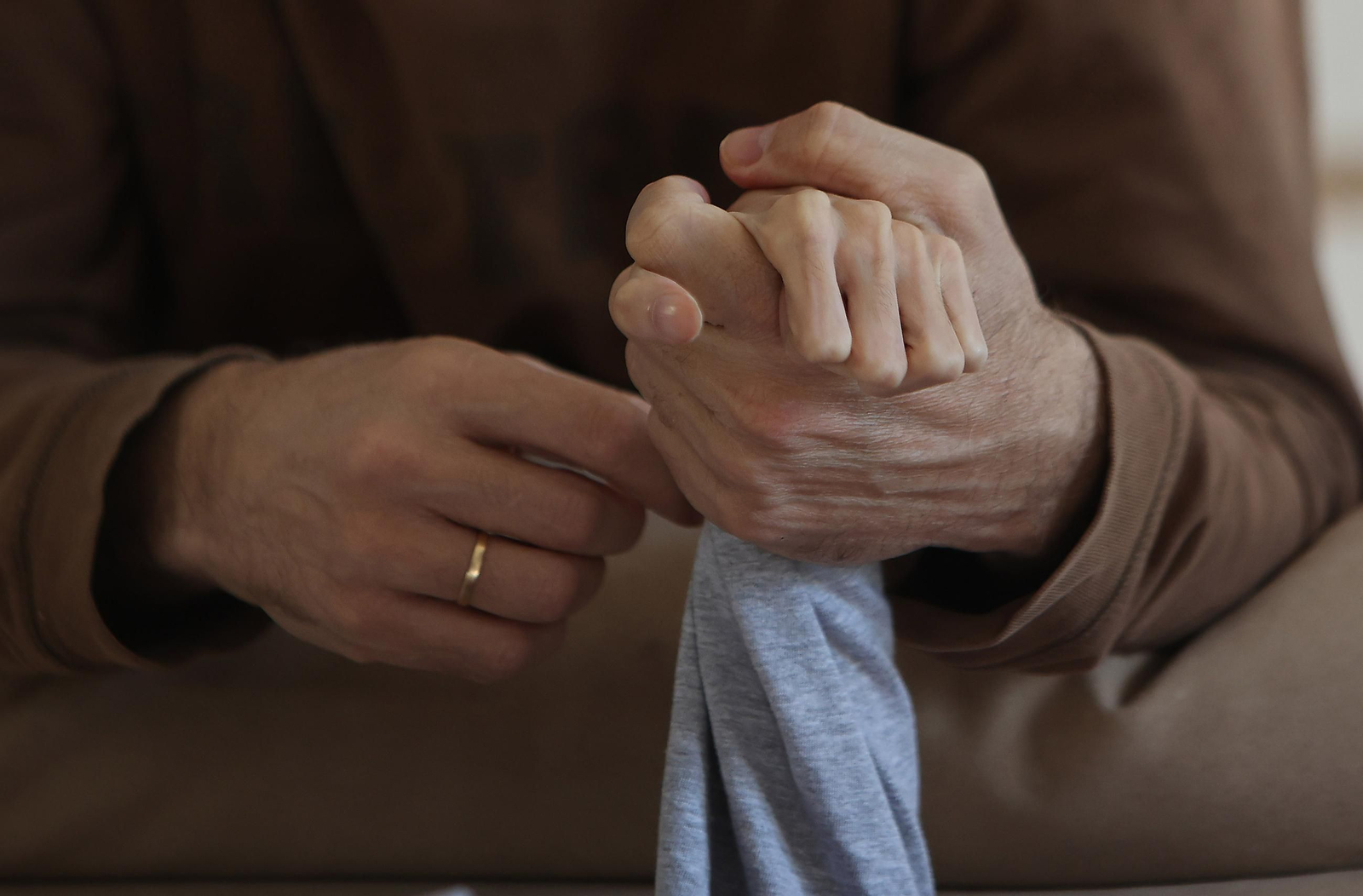 Un padre agarra la mano de su hijo encamado por una enfermedad incurable.