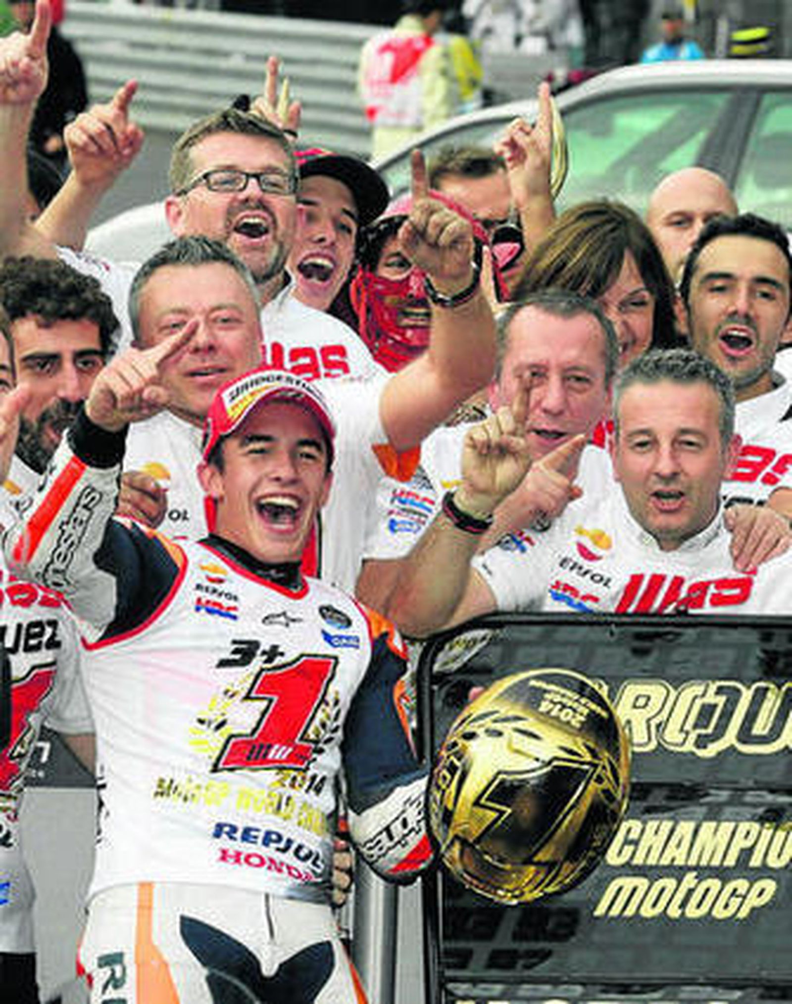 Marc Márquez posa, junto a su equipo, con un cartel conmemorativo.