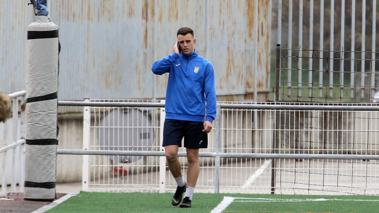 Álex Guti, hablando por teléfono, aguarda su salida del Deportivo.