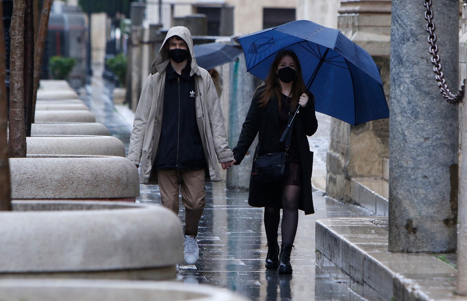 Una pareja camina bajo la lluvia este domingo por el centro de Sevilla.