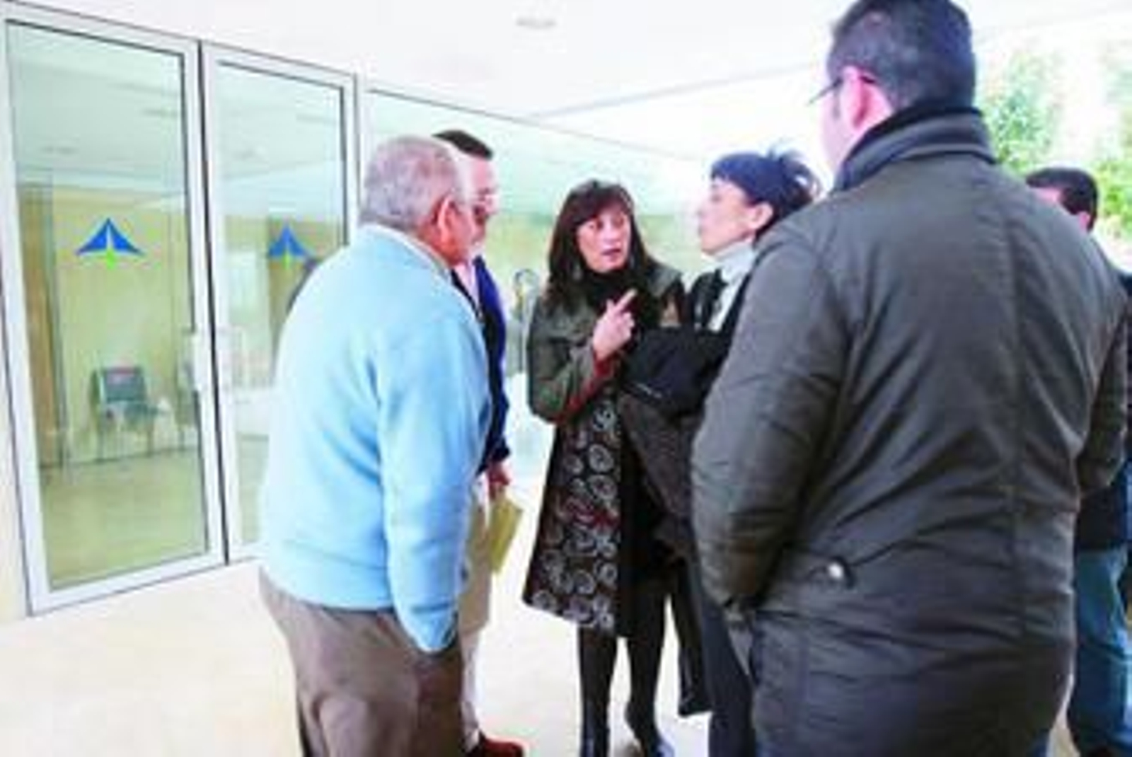 La abogada Trinidad García conversa con un grupo de parcelistas.