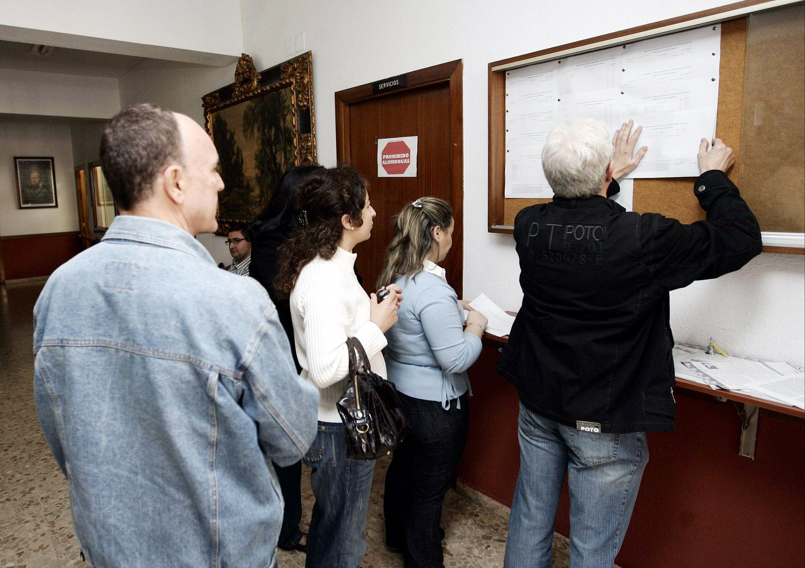 Padres comprueban el listado de alumnos admitidos en un colegio.