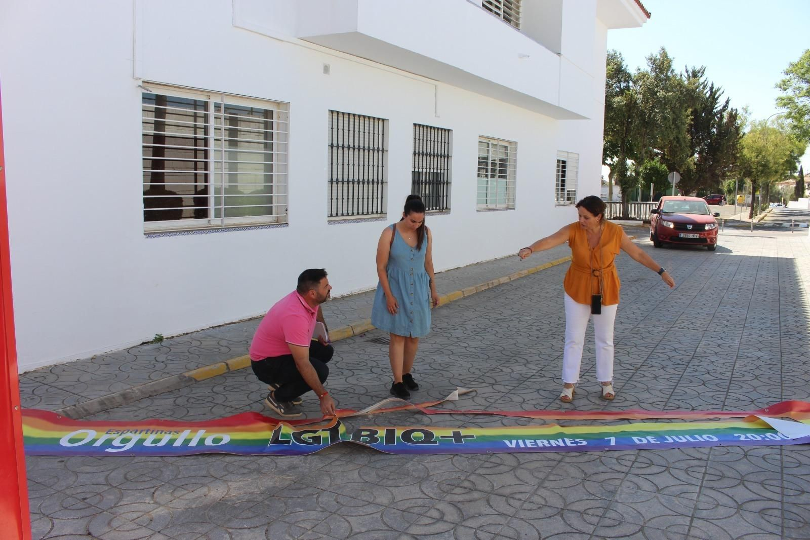 La alcaldesa del municipio, Cristina Los Arcos, junto a dos concejales observan la lona destrozada.